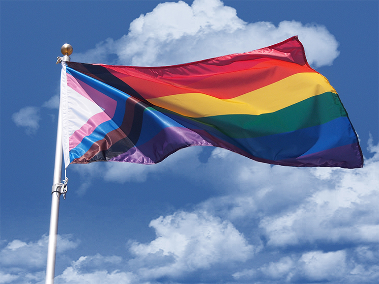 All Inclusive Pride Flag flies against a blue sky